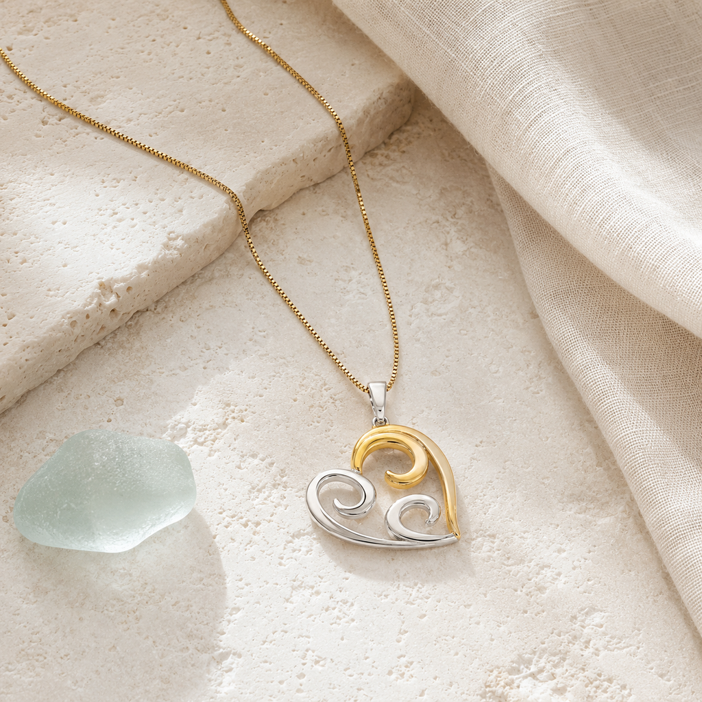 Two-tone open heart necklace styled with ivory linen and sea glass